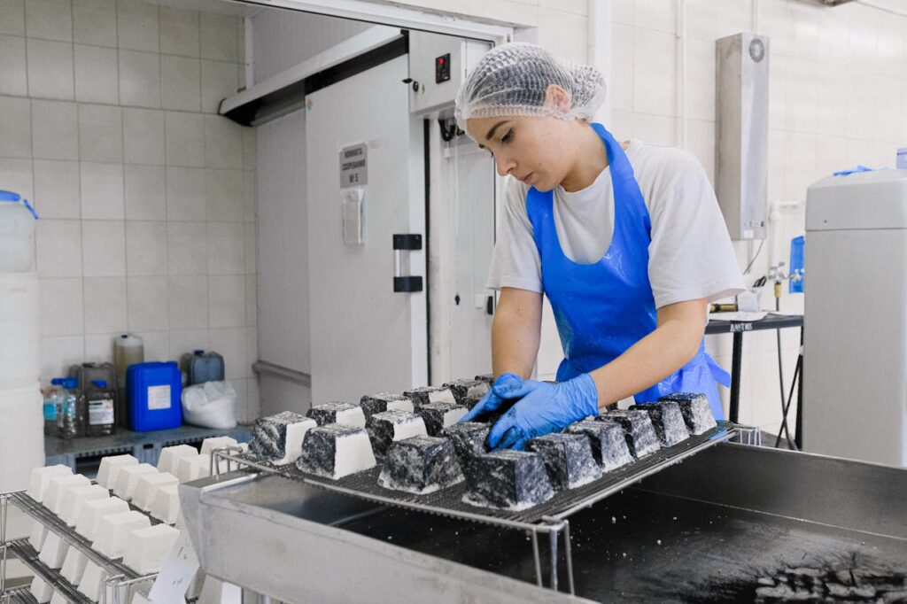Crafting Captivating Headlines: Your awesome post title goes here A worker in a cheese factory examines cheese blocks during production, focusing on quality control.